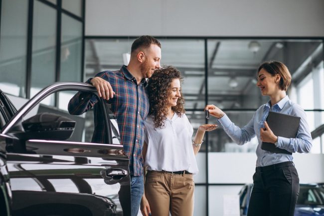 Photo of couple getting keys of new car illustrates blog: "What Is Actual Cash Value in Auto Insurance?"