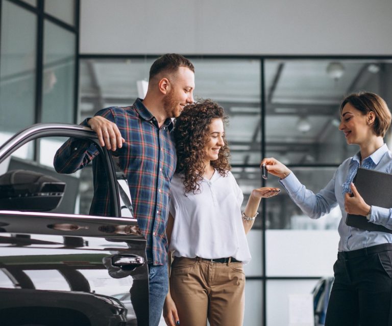 Photo of couple getting keys of new car illustrates blog: "What Is Actual Cash Value in Auto Insurance?"