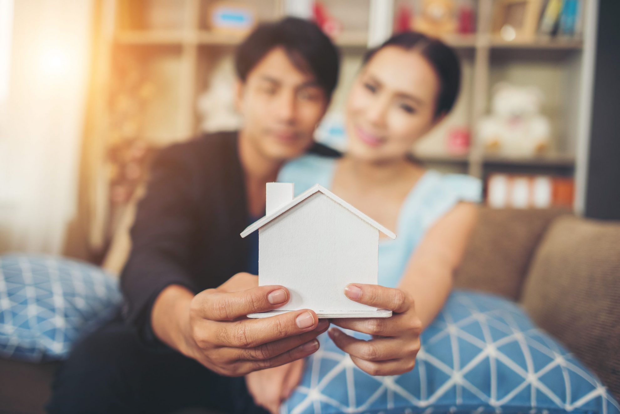 Photo of couple holding model of a home illustrates blog: "What Is Dwelling Fire Insurance?"