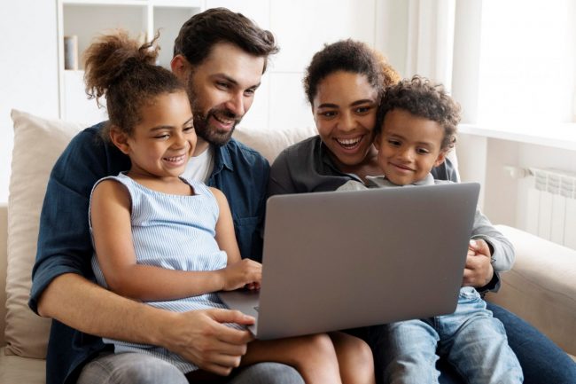 Photo of family looking at laptop illustrates blog: "What Factors Affect the Cost of Home Insurance?"