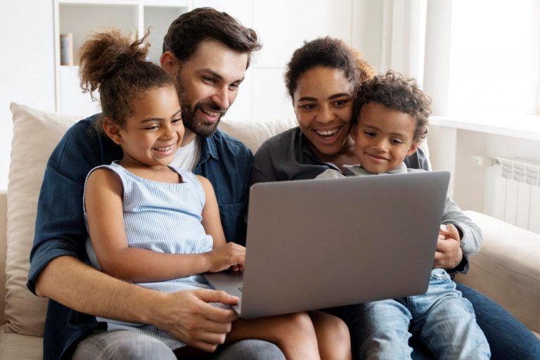 Photo of family looking at laptop illustrates blog: "What Factors Affect the Cost of Home Insurance?"