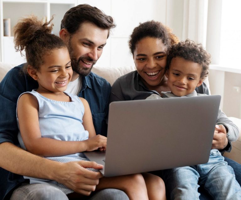 Photo of family looking at laptop illustrates blog: "What Factors Affect the Cost of Home Insurance?"