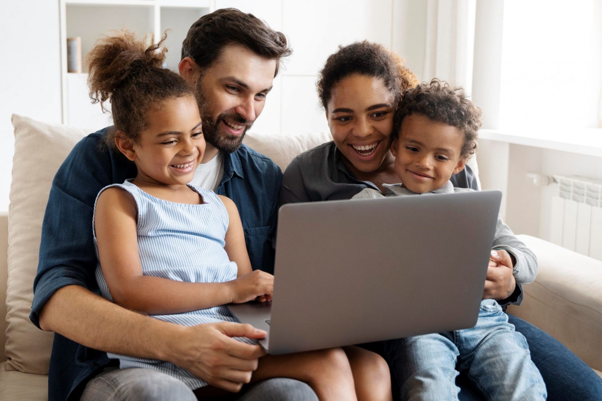 Photo of family looking at laptop illustrates blog: "What Factors Affect the Cost of Home Insurance?"