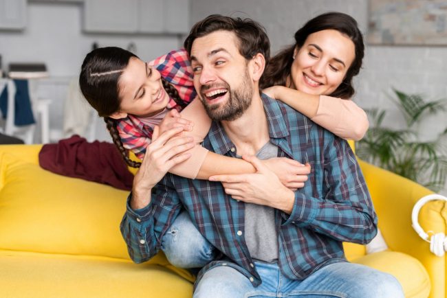 Photo of happy family in living room illustrates blog: "Why Choose Safeco as Your Insurance Company?"