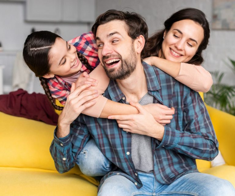 Photo of happy family in living room illustrates blog: "Why Choose Safeco as Your Insurance Company?"