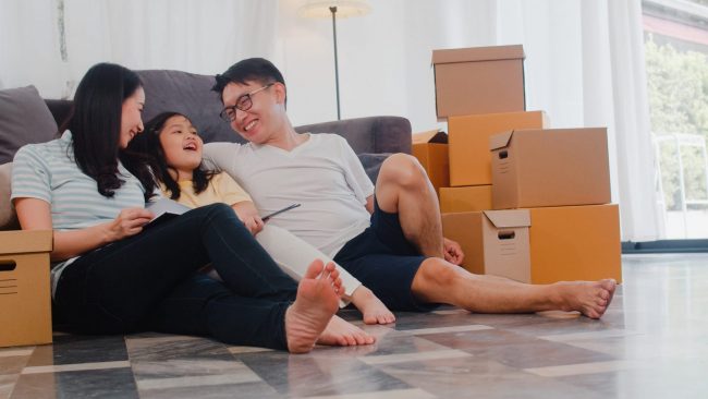 Photo of family sitting on the floor illustrates blog: "What Are the 16 Perils Covered by a Homeowners Insurance Policy?"