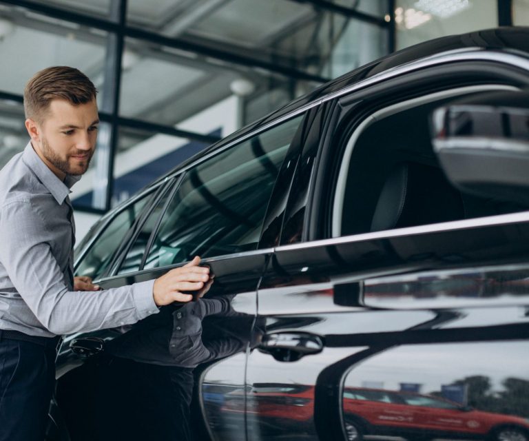 Man looking at car illustrates blog: "Auto Insurance: OEM Parts vs Aftermarket Parts"