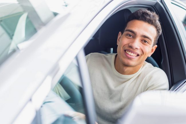 Smiling man in car illustrates blog "Will Auto Insurance Cover Paint Damage?"