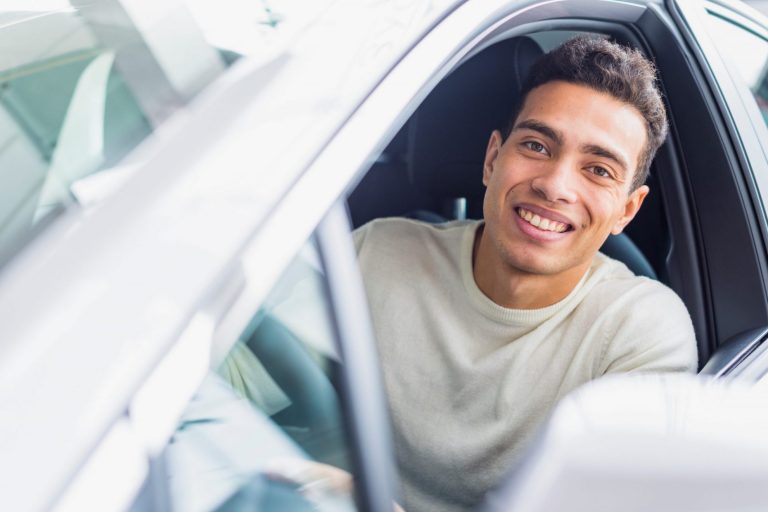 Smiling man in car illustrates blog "Will Auto Insurance Cover Paint Damage?"