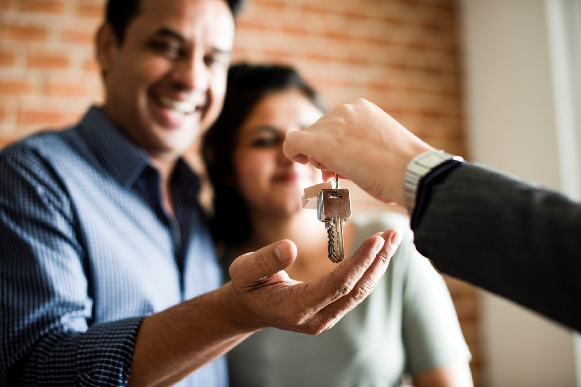 Photo of couple receiving keys illustrates blog: "How Does Renters Insurance Work?"