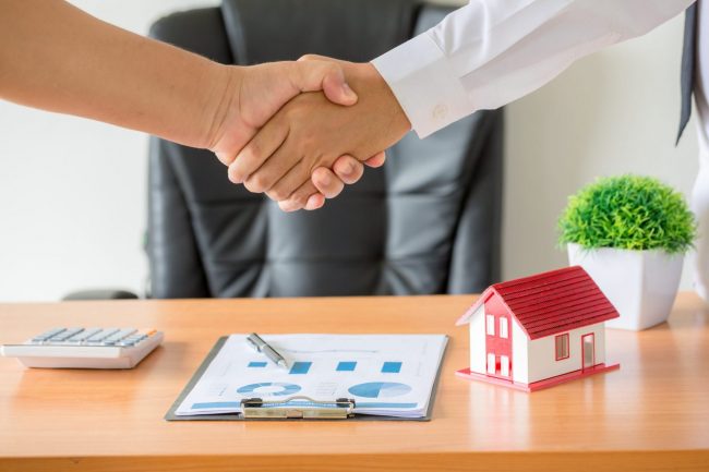 Photo of people shaking hands with small house on the background illustrates blog: "Is Renters Insurance Required in California?"