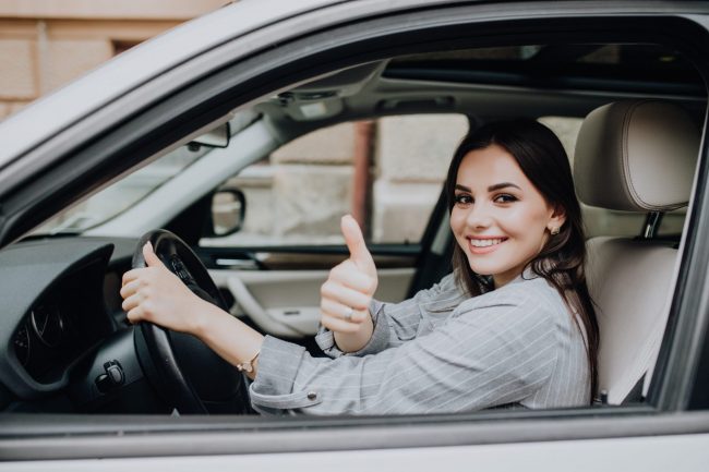 Photo of smiling woman in car giving thumbs up illustrates blog: "Auto Insurance: What Is Full Coverage Car Insurance in California?"
