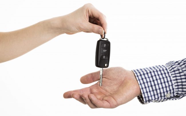 car-keys Closeup of woman handing car keys to man illustrates blog "Does Auto Insurance Cover Lost Keys?"