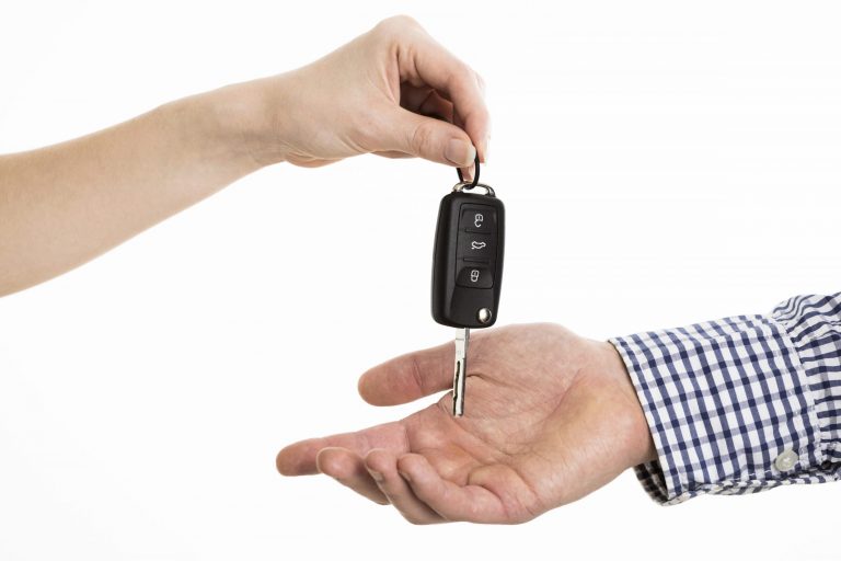 Closeup of woman handing car keys to man illustrates blog "Does Auto Insurance Cover Lost Keys?"