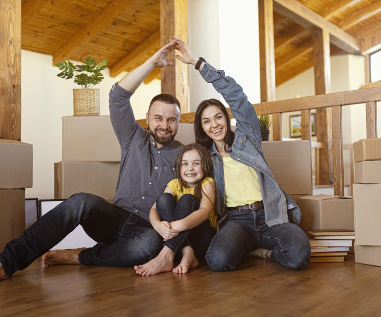 family-home-fp3 Family of mom, dad, and daughter sitting on the floor illustrate blog 'How Are Home Insurance Premiums Calculated?"