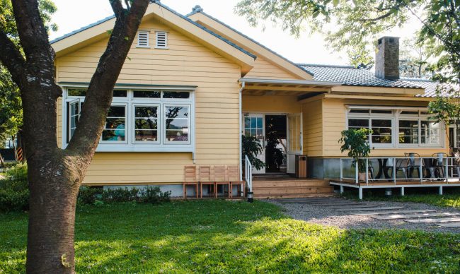 home-wirestock Yellow home with green lawn