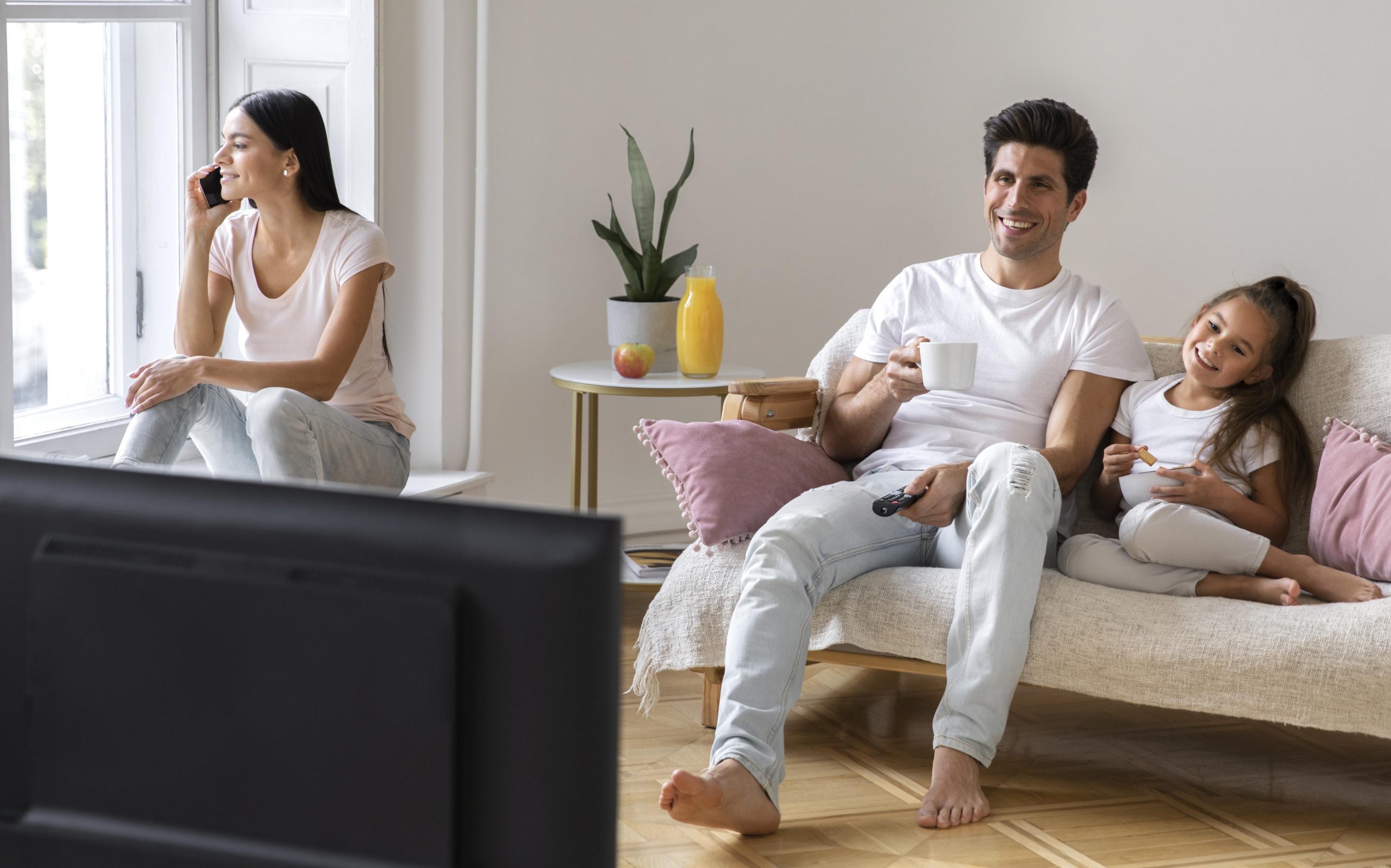 hvac-insurance Mom, dad, and daughter sitting in living room illustrates blog "Will Home Insurance Cover a Broken HVAC?"