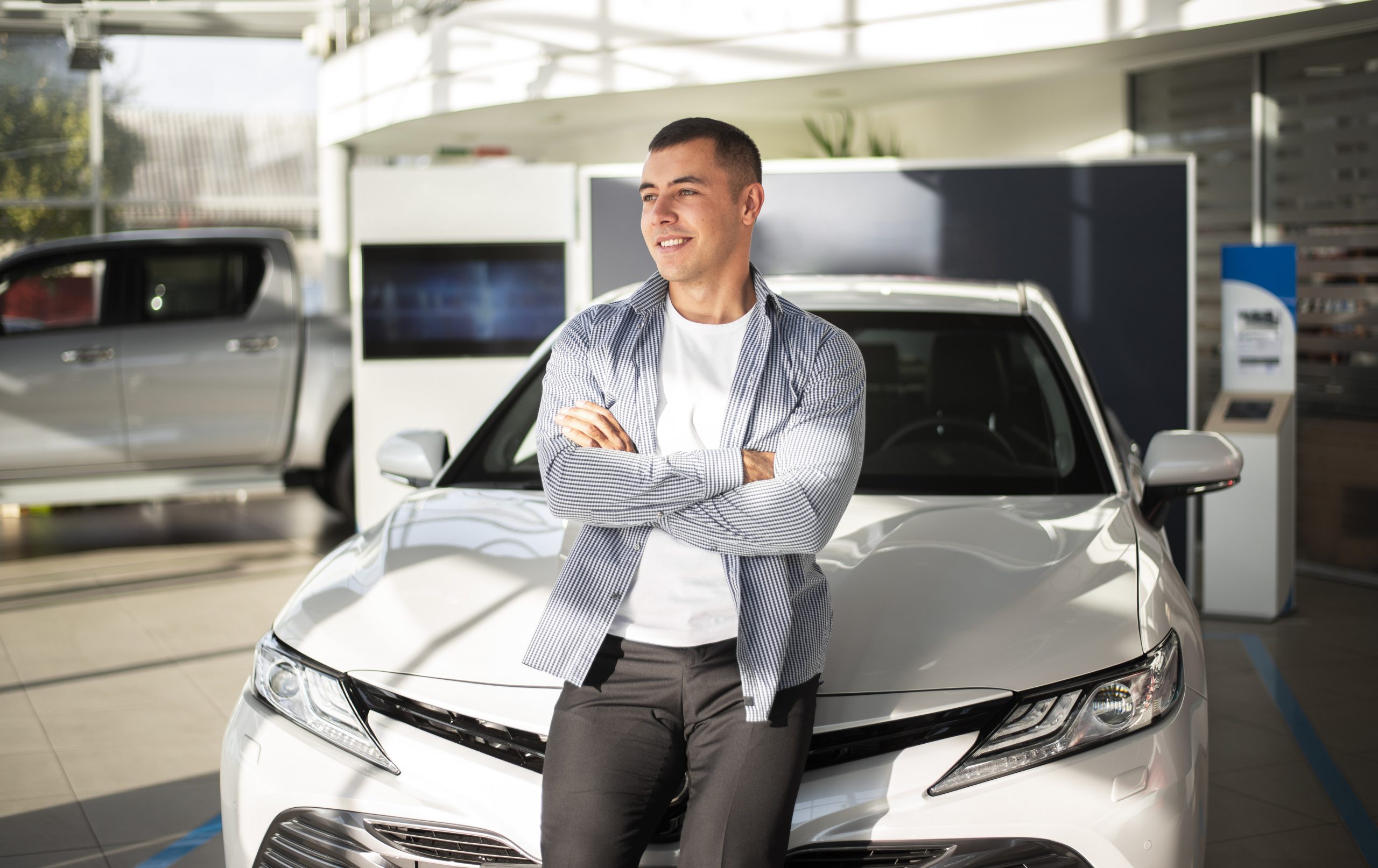 Man leaning against car illustrates blog "Auto Insurance: Is California a No-Fault State?"