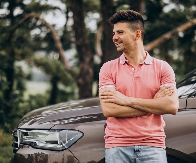 Man leaning against SUV illustrates blog "Is Auto Insurance Paid in Advance?"